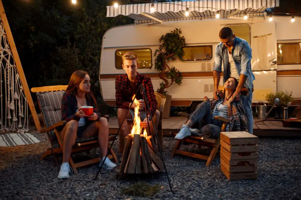 Friends gathered in front of camper enjoying best gifts for RV Owners