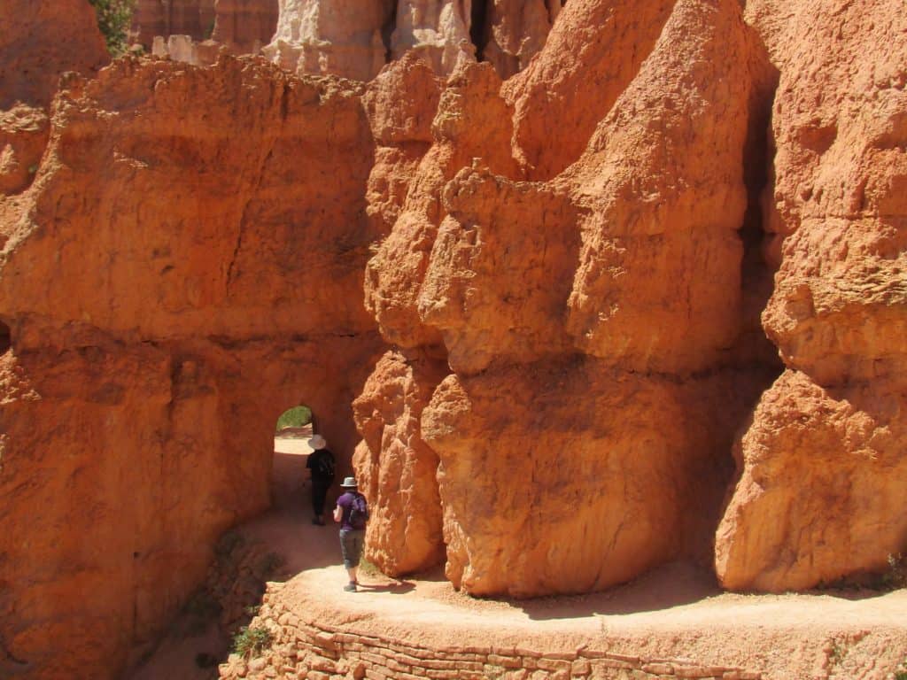 Hiker walking into rock tunnel