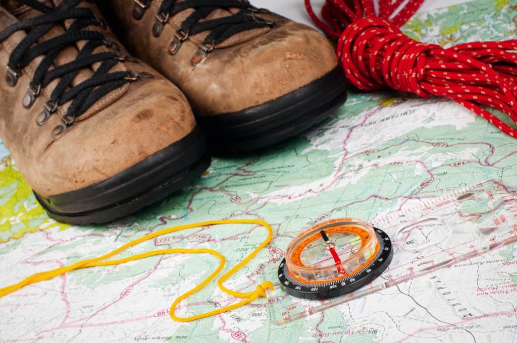 compass and map with hiking shoes, critical for day hiking packing list