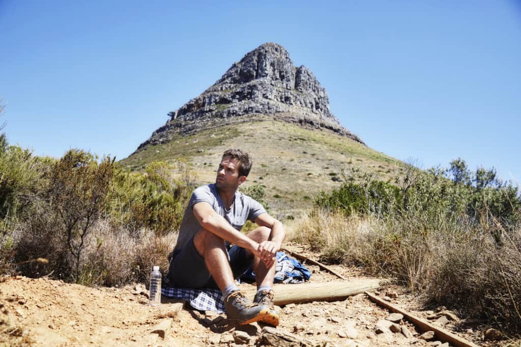 Man sitting on mountainside wearing the best men's hiking shorts