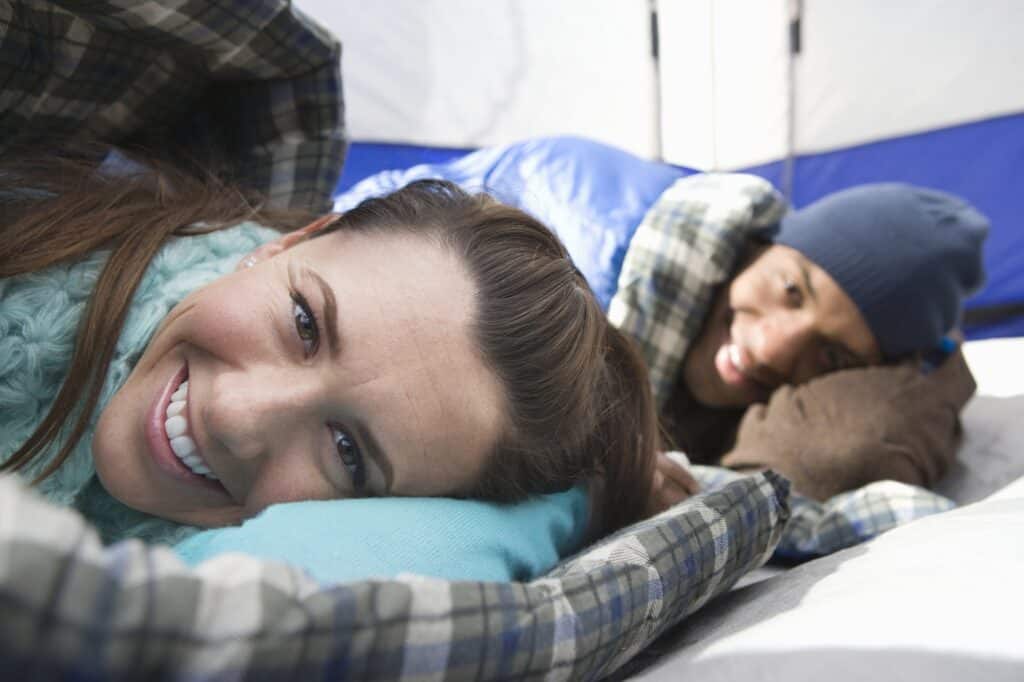 Couple sleeping on camping pillows in tent