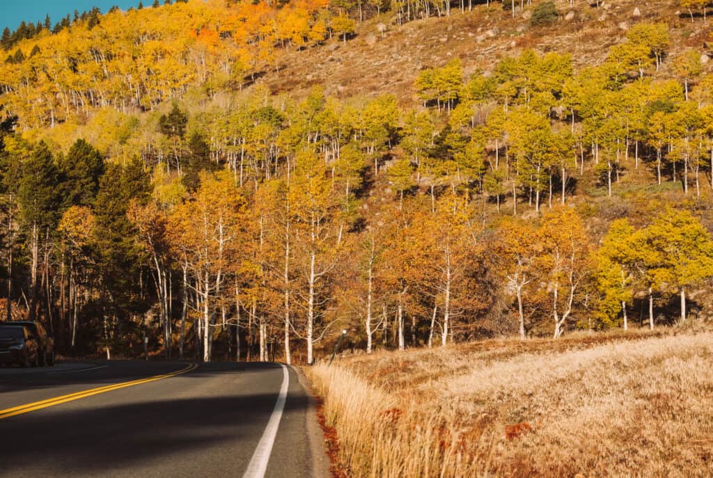 Highway at autumn sunny day in Rocky Mountain National Park. Colorado, USA.