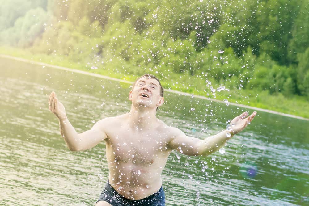 Hiker cooling off on hot day in river