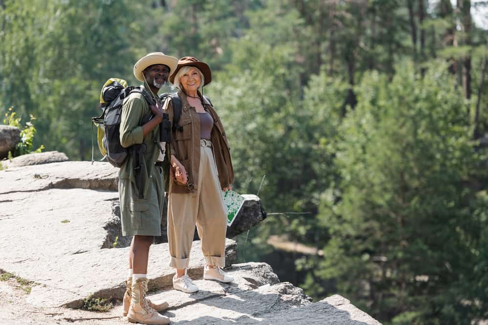 Couple standing on rock ledge dressed for hot weather hiking