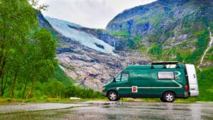 Green Campervan against the backdrop of a glacier and mountain