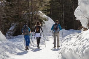three hikers walking on packed snow with microspikes