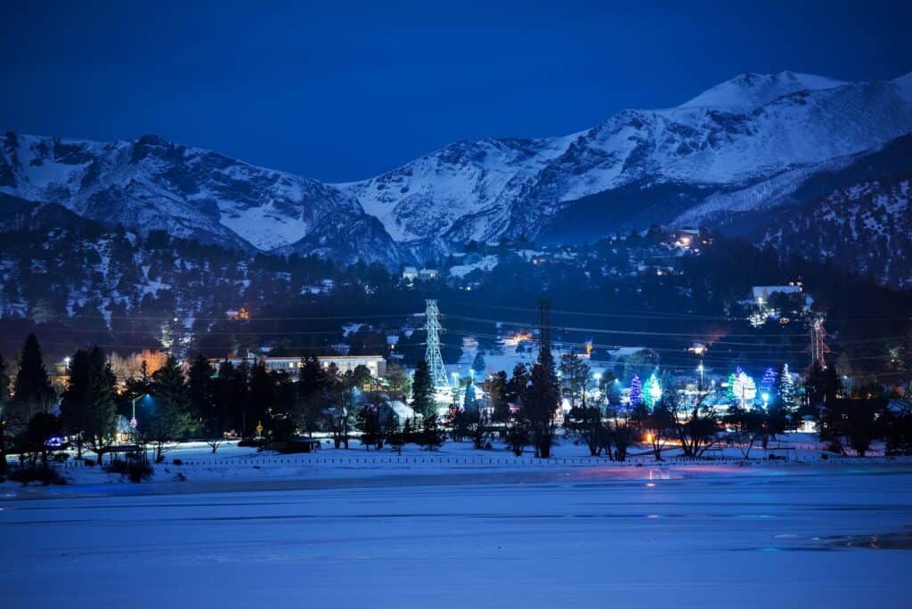 Estes Park at night with lights against the snow showing the town is near Rocky Mountain National Park