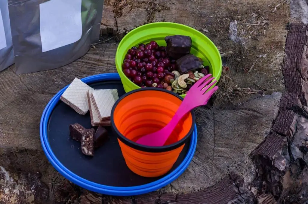 Collapsible Bowls filled with hiking lunch sitting on tree stump