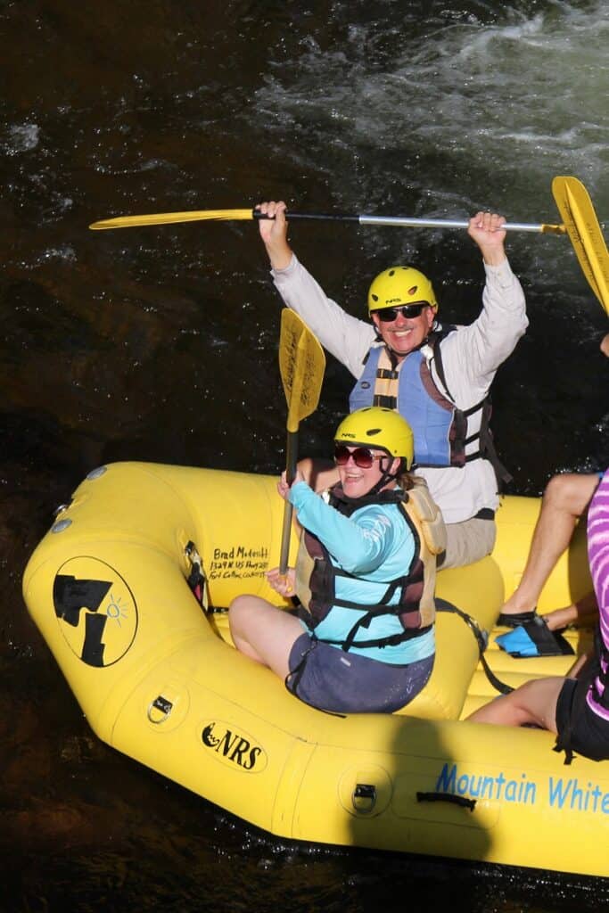 rafting boat with people raising their oars in the air