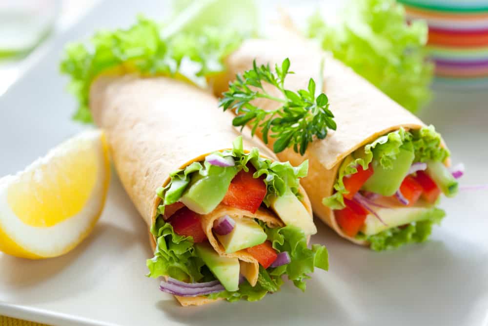 Vegetable wrap on white plate with lemon slice