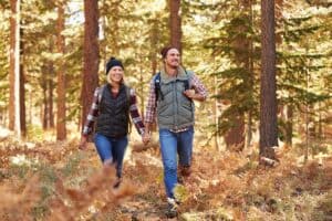 Couple in forest in fall hiking in jeans