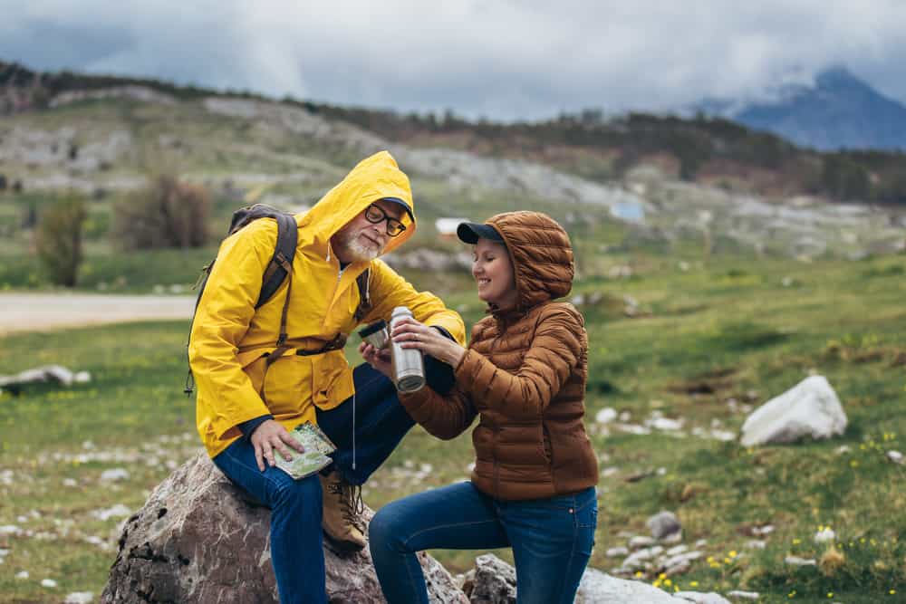 couple hiking in rain in denim jeans