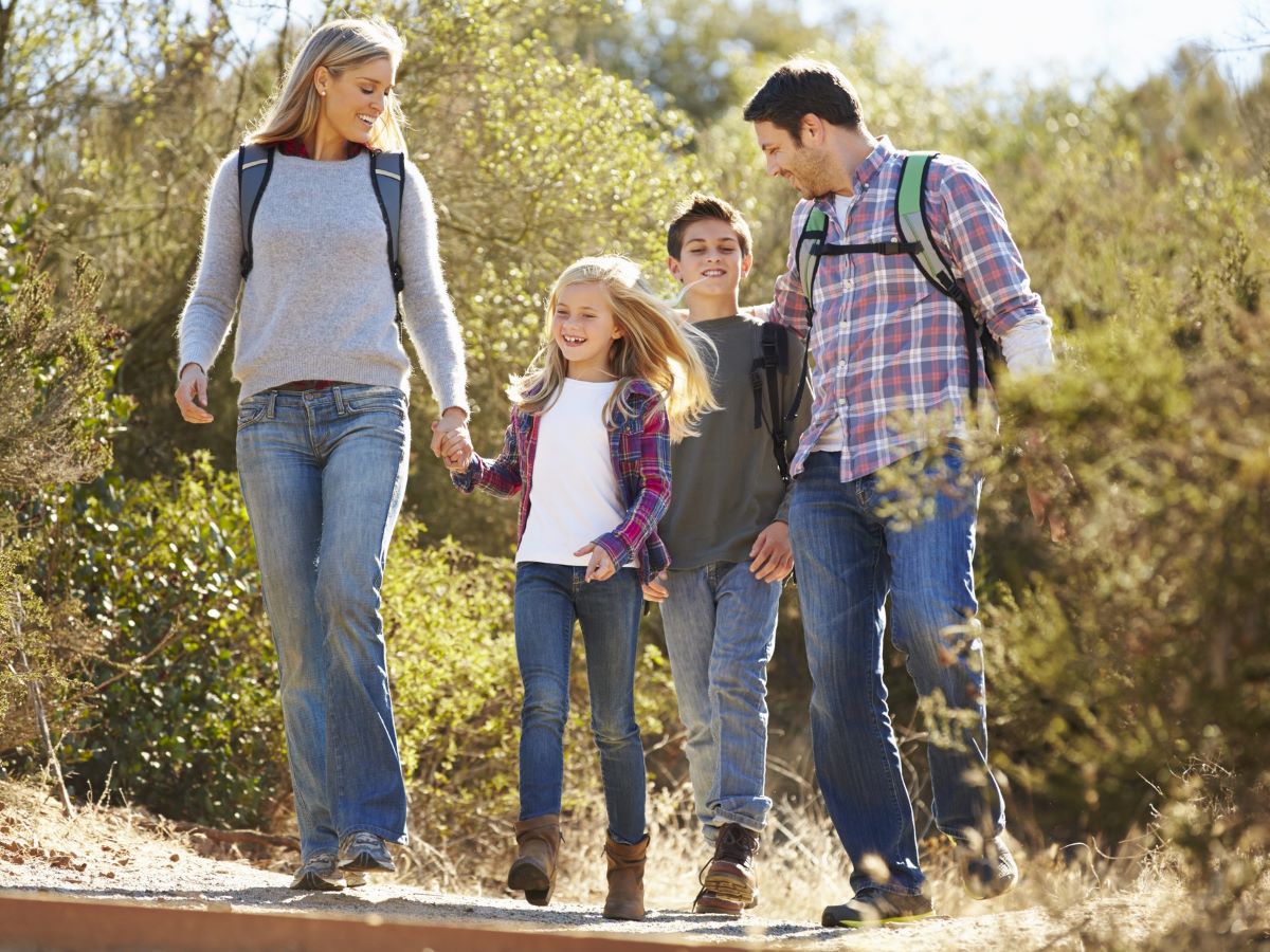 Family Hiking in the woods. Mom, Dad and 2 kids