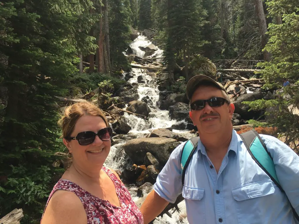 Brad and Ladona sitting in front of Cascade Falls in Rocky Mountain National Park