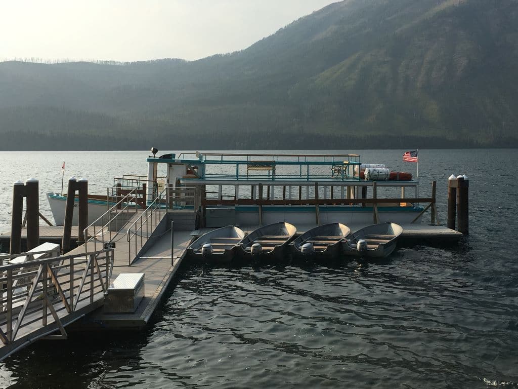 Boat docks behind Lake McDonald Lodge, with 4 rowboats and historic wooden boat docked