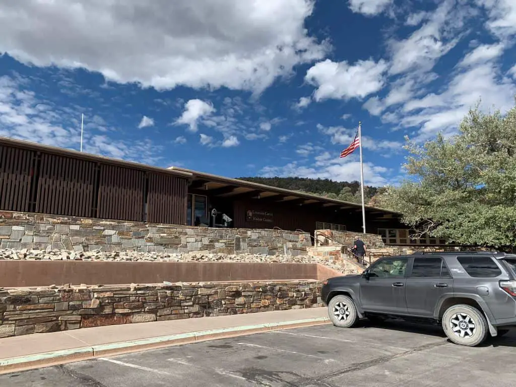 Lehman Cave Visitor Center in Great Basin National Park with a car in front and a man walking up the steps