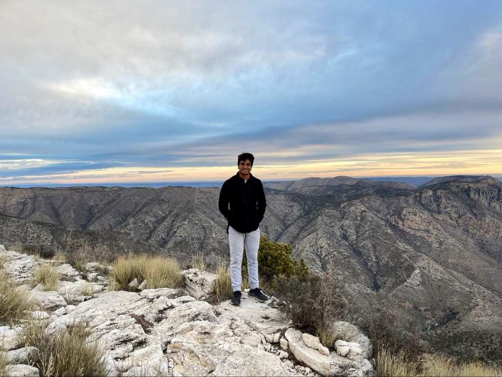 Guadalupe Peak Sunrise with hiker standing on top of summit