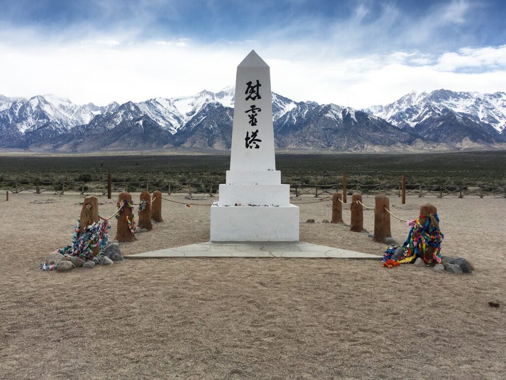 white manzanar shrine in national park with sand in forground and mountains in back
