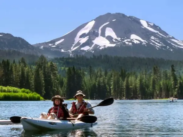 Kayak with 2 people on lake with mountain in background