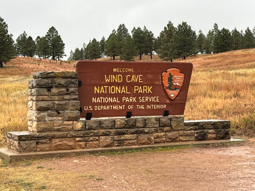 Entrance sign to wind cave national park with prairie in background