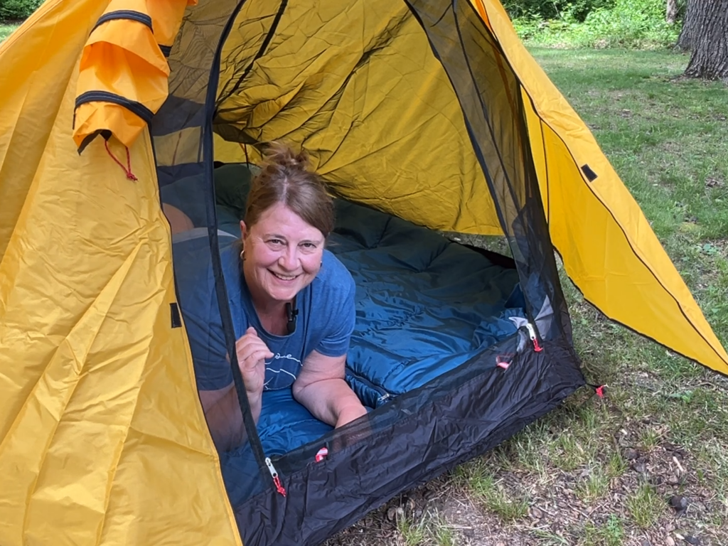 woman looking out door of tunnel tent